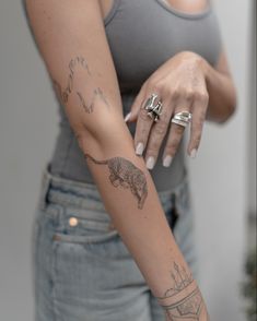 a woman with tattoos on her arm and wrist