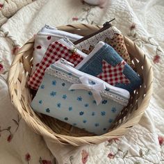 a basket filled with lots of different types of purses on top of a bed