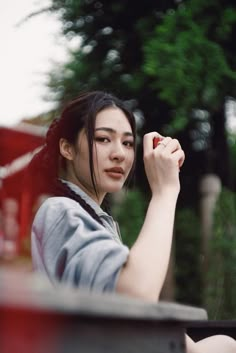 a woman is sitting outside writing something on her finger