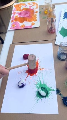 the child is painting on paper with paint