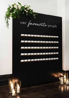 candles are lit in front of a sign that says our favorite people on the wall