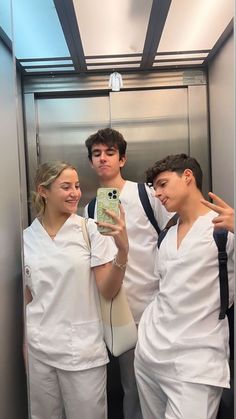 three people in white scrubs taking a selfie