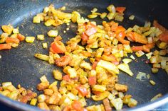 chopped vegetables being cooked in a pan on the stove