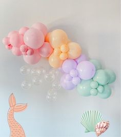 some balloons are floating in the air next to a mermaid tail and seashells