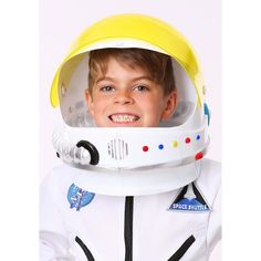 a young boy wearing an astronaut's helmet and white space suit with yellow visor