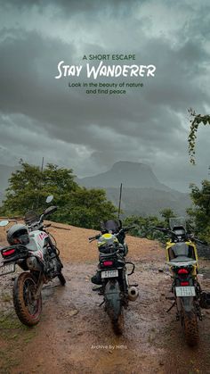 two motorcycles parked on the side of a dirt road