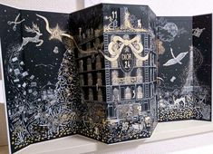 an open book with black and gold designs on it