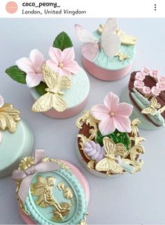 four decorated cupcakes sitting on top of a white table next to each other