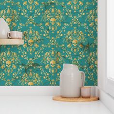 a teal wallpaper with yellow and green floral designs on the walls, along with two white vases