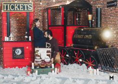 a man and woman standing in front of a fake train