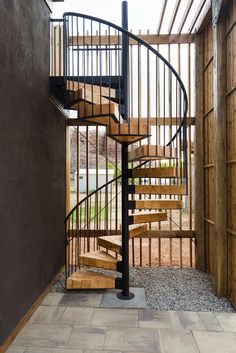 a metal spiral staircase with wooden handrails