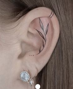 a close up of a person's ear with a flower tattoo on the side