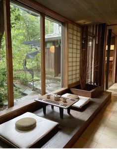 a room that has some kind of table on it in front of large glass windows