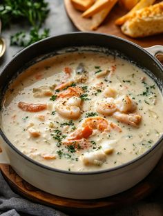 a bowl of shrimp chowee with bread on the side