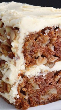 a piece of carrot cake with white frosting on a plate