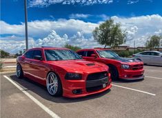 two red cars parked in a parking lot