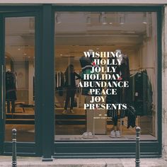 a store front window with the words wishing holly holiday abundance peace joy presents