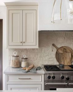 a kitchen with an oven, stove and counter top in the middle of it's white cabinetry