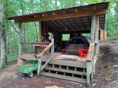 a small wooden cabin in the woods with stairs leading up to it's porch