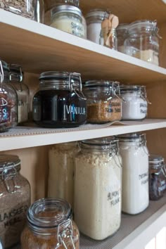 shelves filled with various types of food and spices in glass jars on top of each other