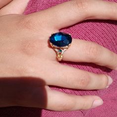 a woman's hand with a blue ring on it