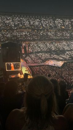 a large crowd at a concert with lights on the stage and people in the stands