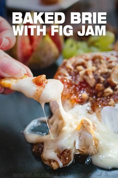 baked brie with fig jam is being drizzled over the cheese and toppings