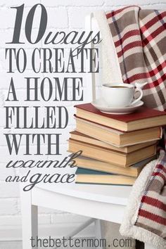 a stack of books sitting on top of a table next to a cup and blanket