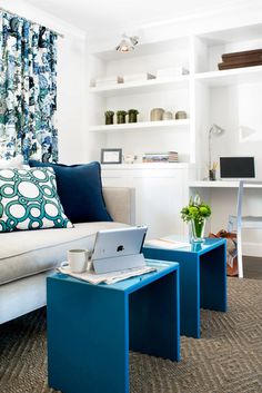 a living room filled with furniture and a laptop computer on top of a coffee table