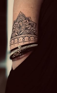 a woman's arm with a tattoo on it and a bracelet around her wrist