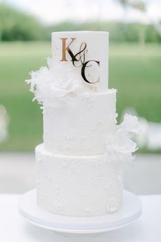 3-tiered white wedding cake Diy White Wedding Decorations, Off White Wedding Cake, 3 Tier Wedding Cake With Initials, Wedding Cake With Flowers And Pearls, Wedding Cake With Initial On Cake, 3 Tier Wedding Cake White And Gold, Wedding Cake Designs Elegant White, 3 Tier Wedding Cake Ideas Elegant