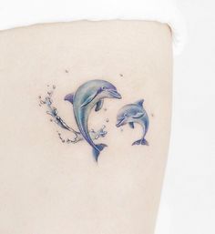 two dolphins on the back of a woman's thigh