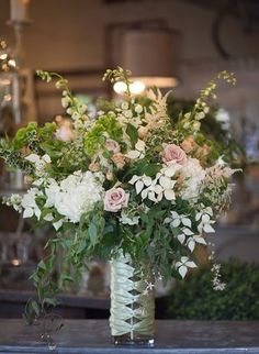 a vase filled with lots of white and pink flowers