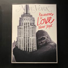 a gorilla is standing in front of a tall building with the words reason to love new york written on it