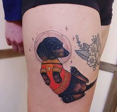 a woman's thigh with a dog in an astronaut suit on her right leg