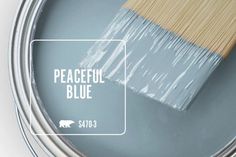 a paint can with the words peaceful blue painted on it, and a brush inside