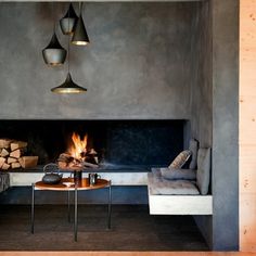 a living room filled with furniture and a fire place next to a wall mounted fireplace