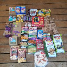 a pile of food sitting on top of a wooden floor next to bags of chips