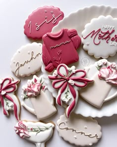 decorated cookies are arranged on a plate for mother's day celebration, with pink and white icing