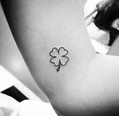 a small four leaf clover tattoo on the left side of the right arm and shoulder