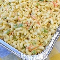 a pan filled with macaroni salad on top of a checkered table cloth