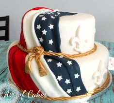 a three tiered cake decorated with the colors of the american flag and fleur de lis