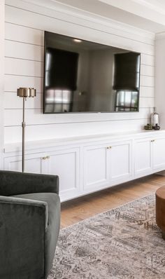 a living room with two couches and a flat screen tv mounted on the wall