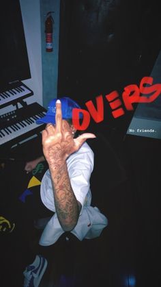 a man making the peace sign with his hand in front of a keyboard and red lettering that reads divers