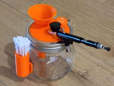 two toothbrushes and an orange cup on a wooden table