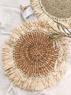 two woven baskets sitting on top of a white cloth covered floor next to each other