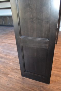 a black door is open on a wooden floor