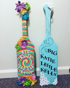 two colorful painted wine bottles sitting next to each other on the floor in front of a wall