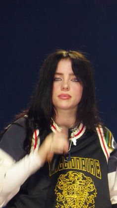 a woman with long hair wearing a black shirt and white gloves is holding her hand out to the side