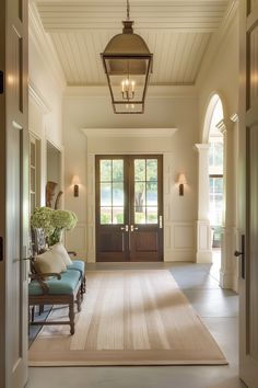 an entry way with a blue bench and light fixture